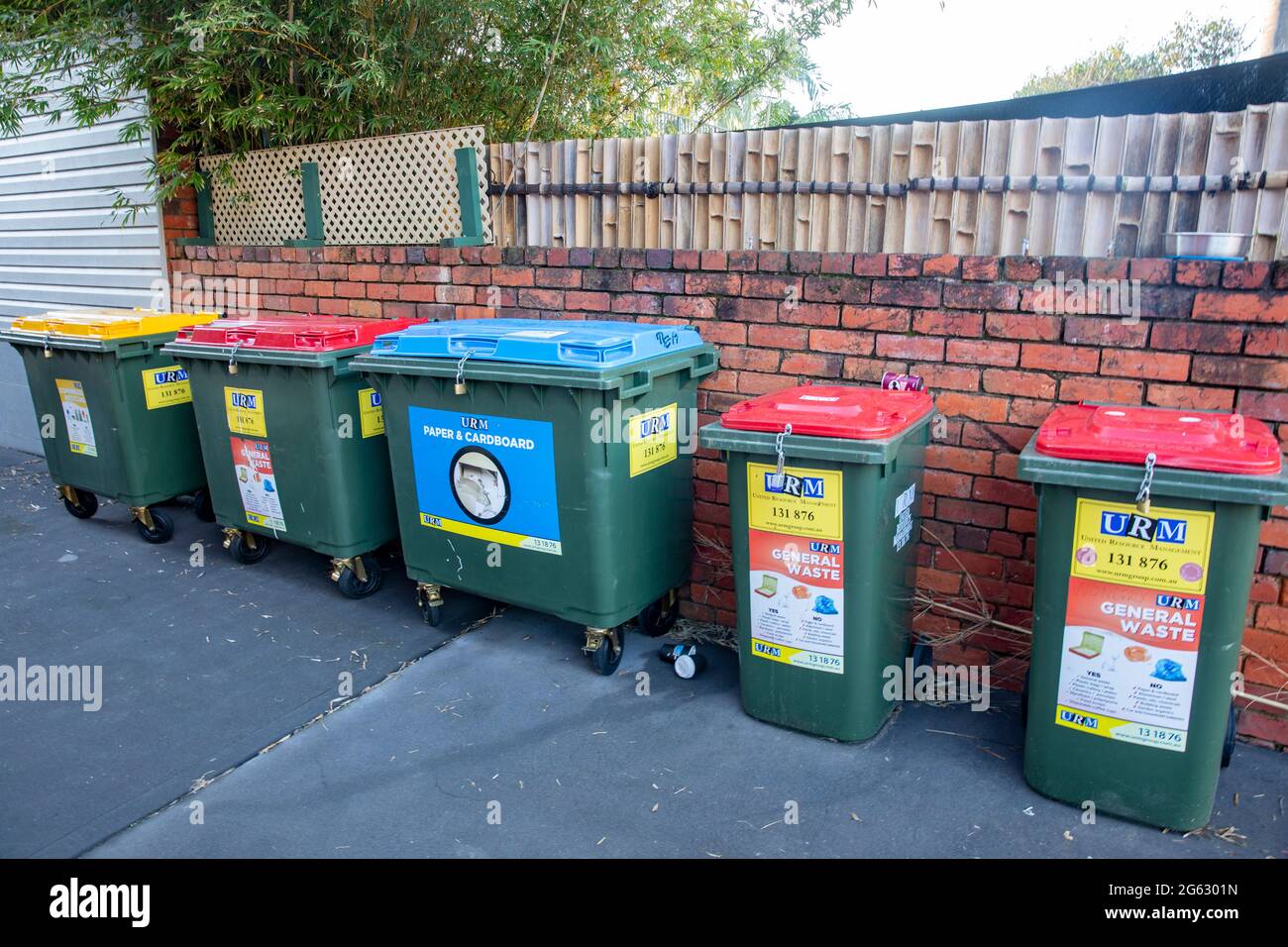 Recycling Abfallbehälter in einer Seitenstraße in Sydney für das Recycling von Flaschen, Papier und Pappe und roten Behältern für den allgemeinen Abfall, Australien Stockfoto