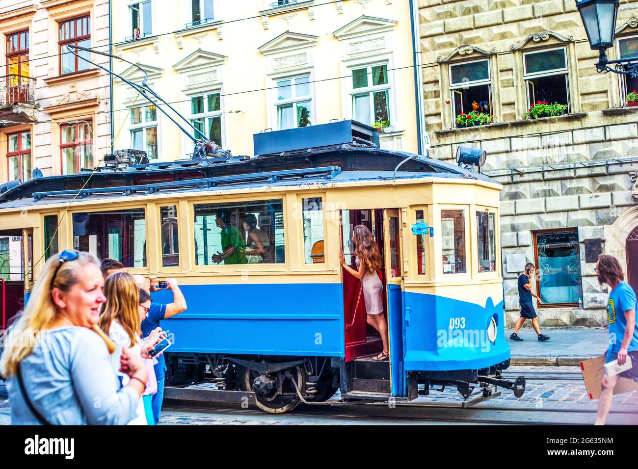 Ukraine, Lviv - 10. August 2020: Passagiere an der Haltestelle und alte Straßenbahn auf dem Marktplatz Stockfoto