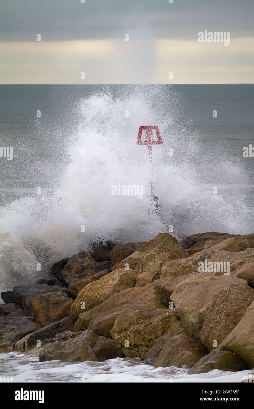 Wellen, die während EINES Wintersturms auf EINER Breakwater, Groyne am Hengistbury Head Beach, stürmen. VEREINIGTES KÖNIGREICH Stockfoto