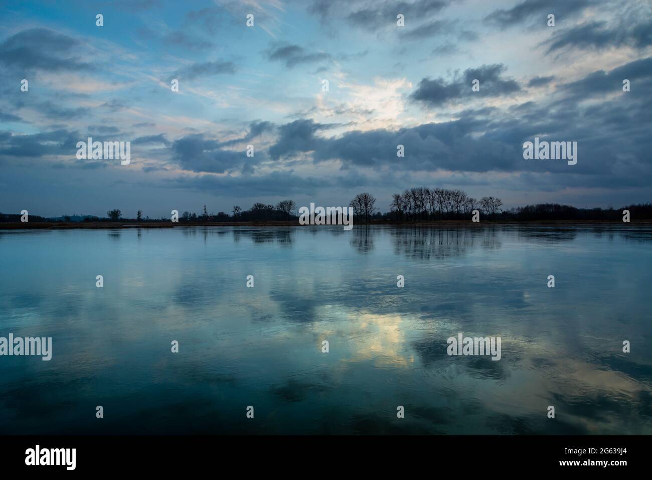 Spiegelung von Abendwolken in einem gefrorenen See, Stankow, Polen Stockfoto