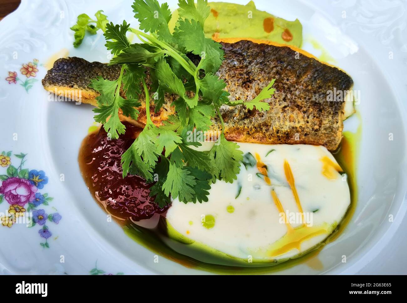 Gebackenes sibas-Fischfilet, garniert mit Gemüse Stockfoto
