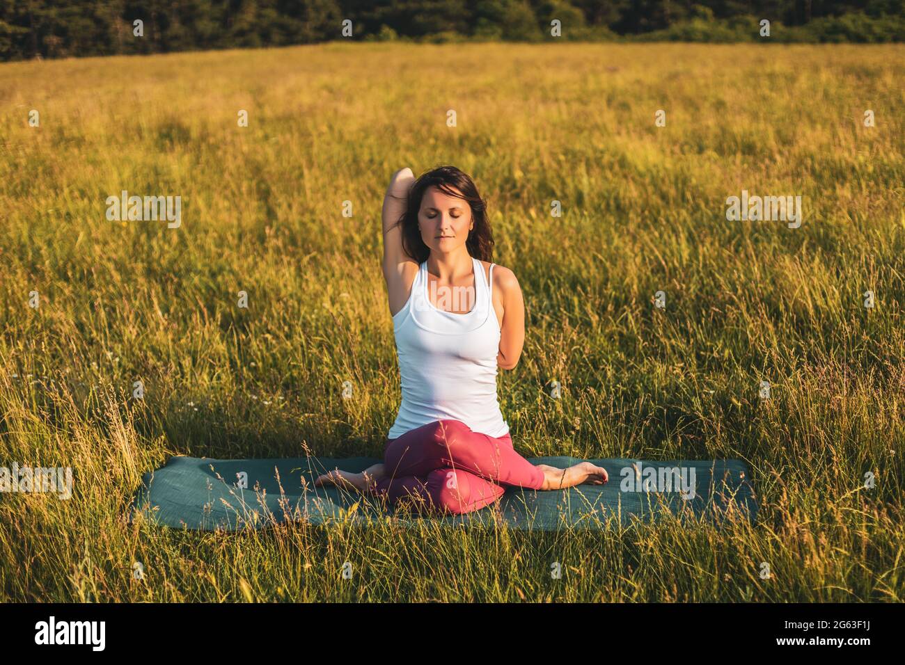 Schöne Frau, die Yoga in der Natur/Gomukhasana, Kuh Gesicht Pose. Stockfoto