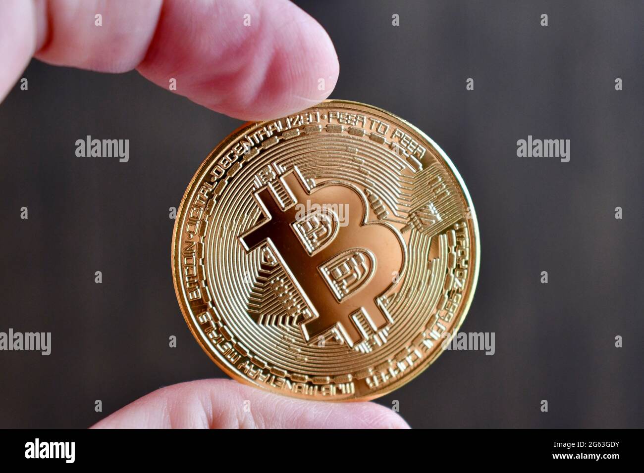 Hand hält einen Bitcoin-Kryptowährung-Token Stockfoto