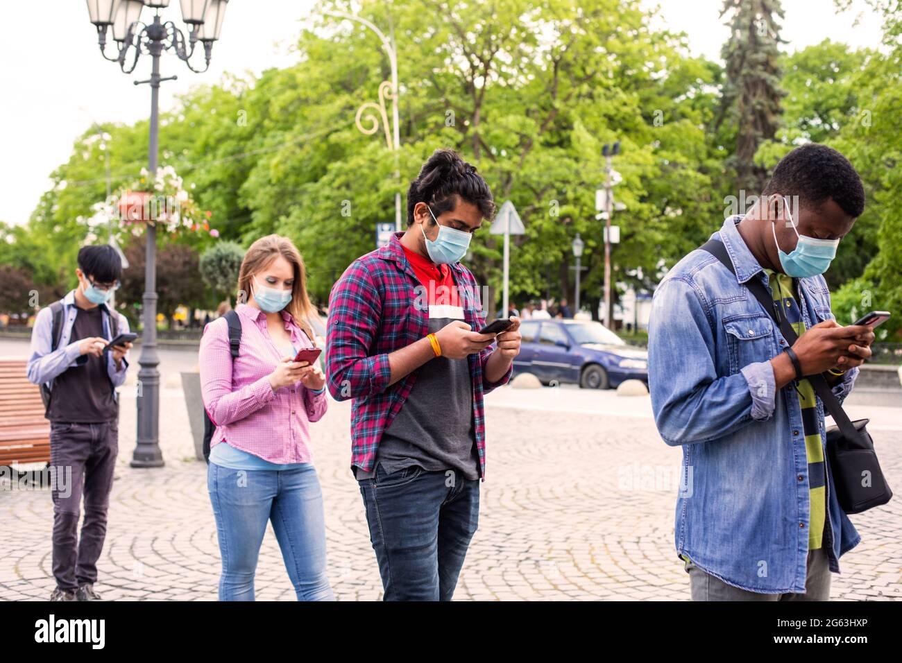 Menschen in Masken stehen Schlange, um soziale Distanz zu bewahren Stockfoto