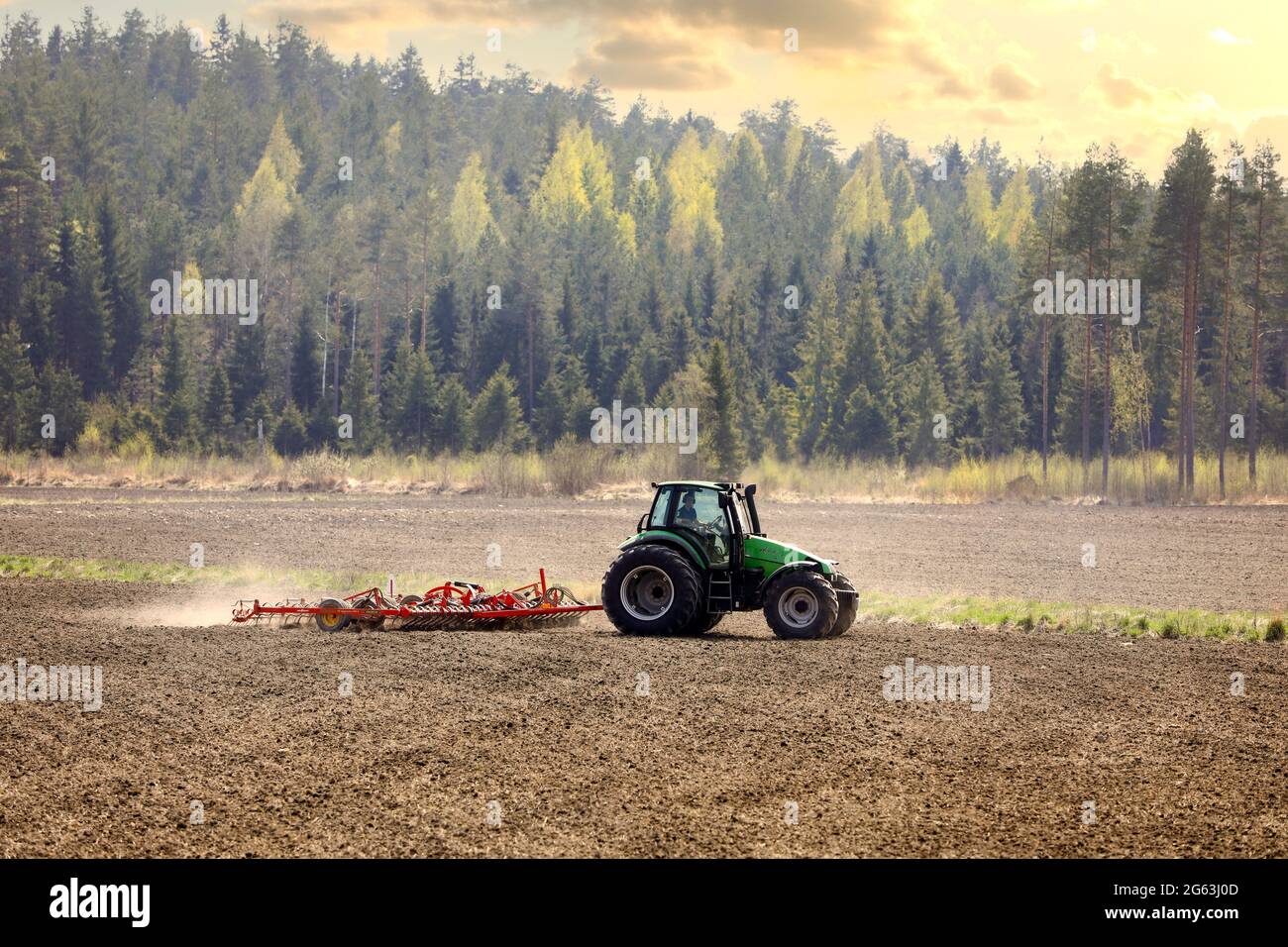 Landwirt kultiviert Feld mit grünen Deutz-Fahr Agrotron 135 Traktor und Vaderstad NZ aggressive Zinkenegge im Frühjahr. Salo, Finnland. 13.Mai 2021 Stockfoto