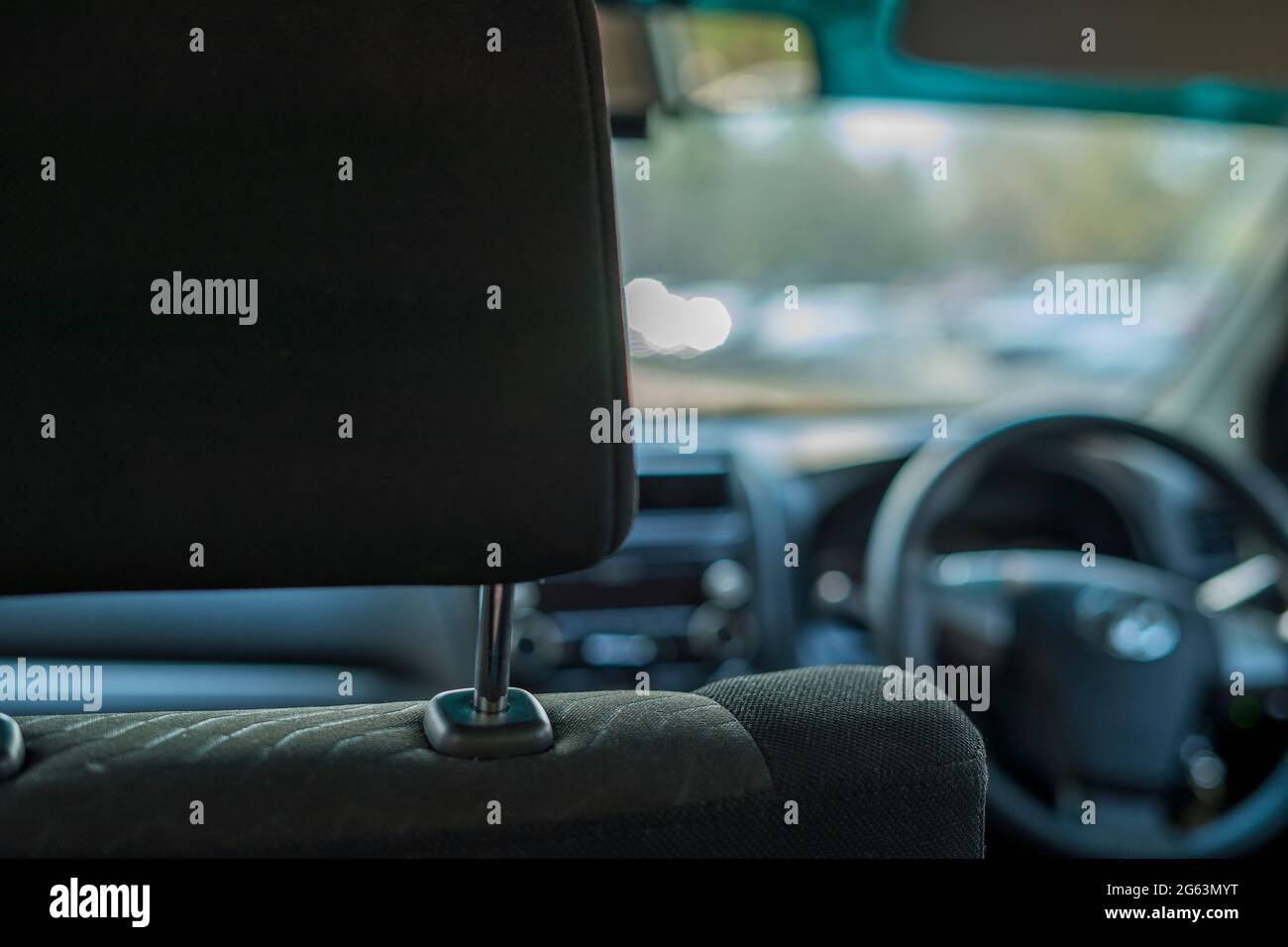 Die Hand passt die Kopfstütze im Innenraum des Fahrzeugs an und passt die Sitzposition im Fahrzeug an Stockfoto