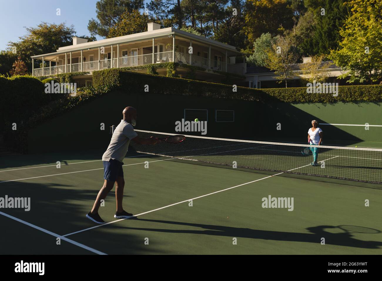 Ein älteres afroamerikanisches Paar spielt Tennis auf dem Tennisplatz Stockfoto