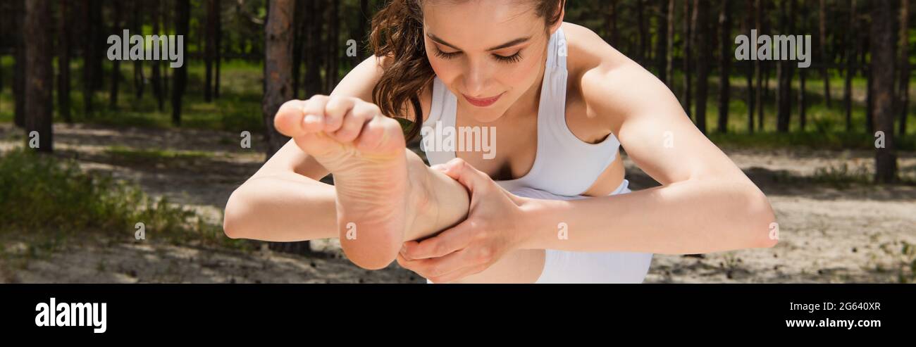 Barfuß Frau in Sportswear Stretching im Wald, Banner Stockfoto