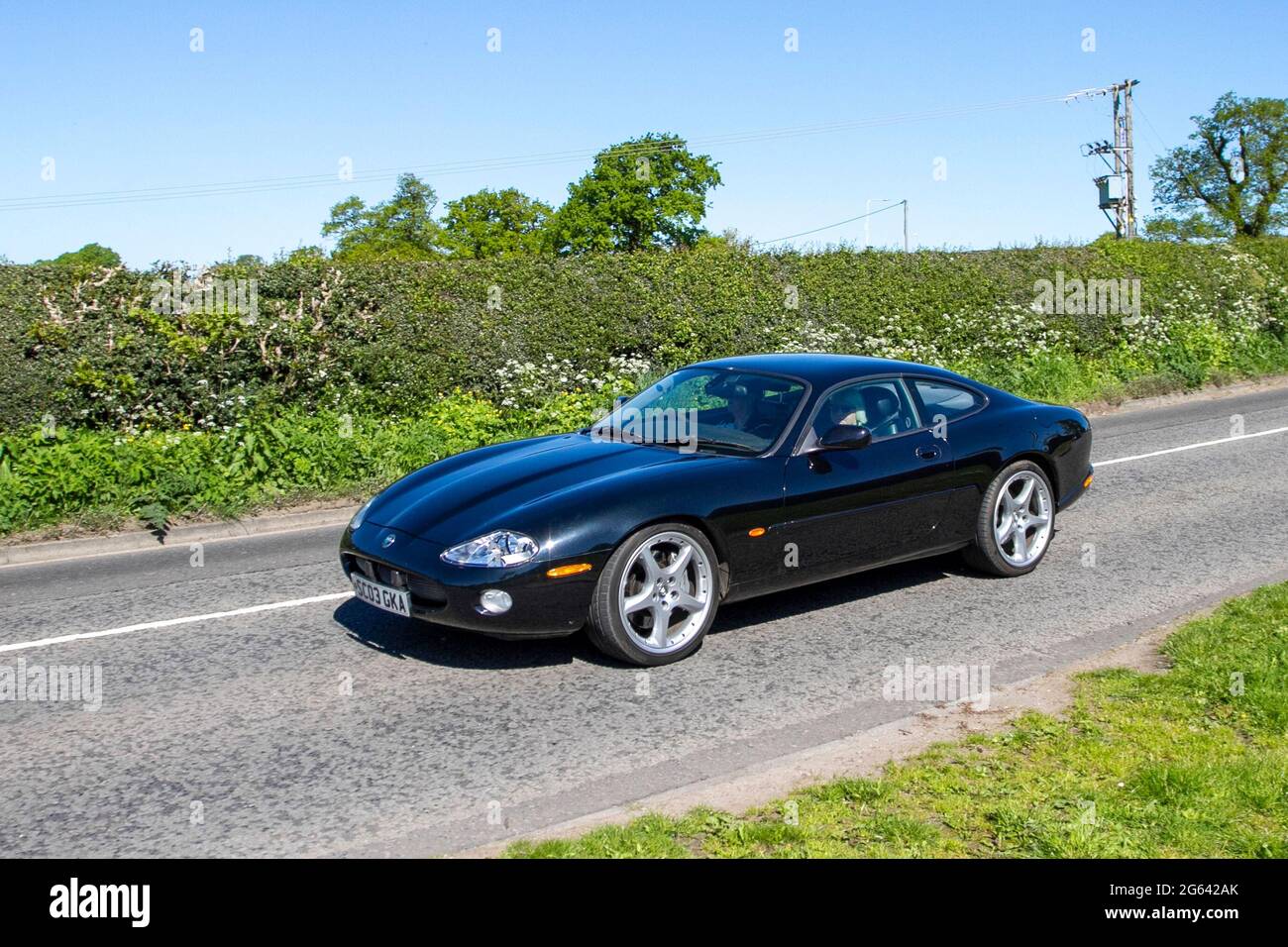 2003 Blaues Jaguar XK8 Coupé Auto 6-Gang-Automatik, 2-türiges Fastback-Coupé mit 4,196 ccm Benzinmotor auf dem Weg zur Capesthorne Hall Classic Car Show im Mai, Cheshire, UKluxus Stockfoto