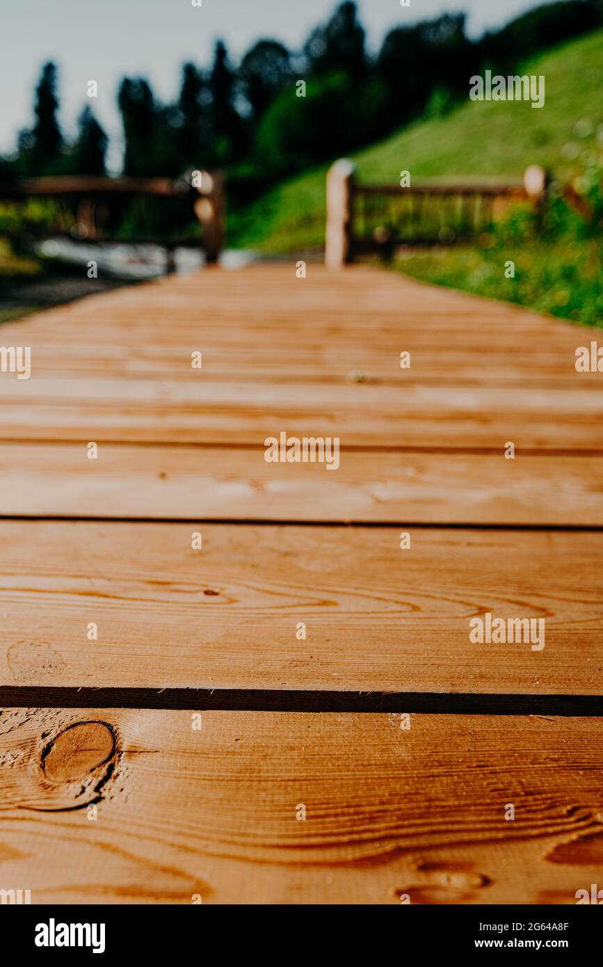 Holzboardwalk in den Bergen, die zu den Hügeln der Aussichtsplattform führt. Der Weg für das Brautpaar. Hintergrundtextur Kontrastsättigung Stockfoto