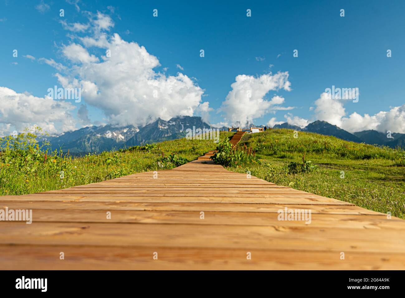 Holzboardwalk in den Bergen, die zu den Hügeln der Aussichtsplattform führt. Der Weg für das Brautpaar. Hintergrundtextur Kontrastsättigung Stockfoto