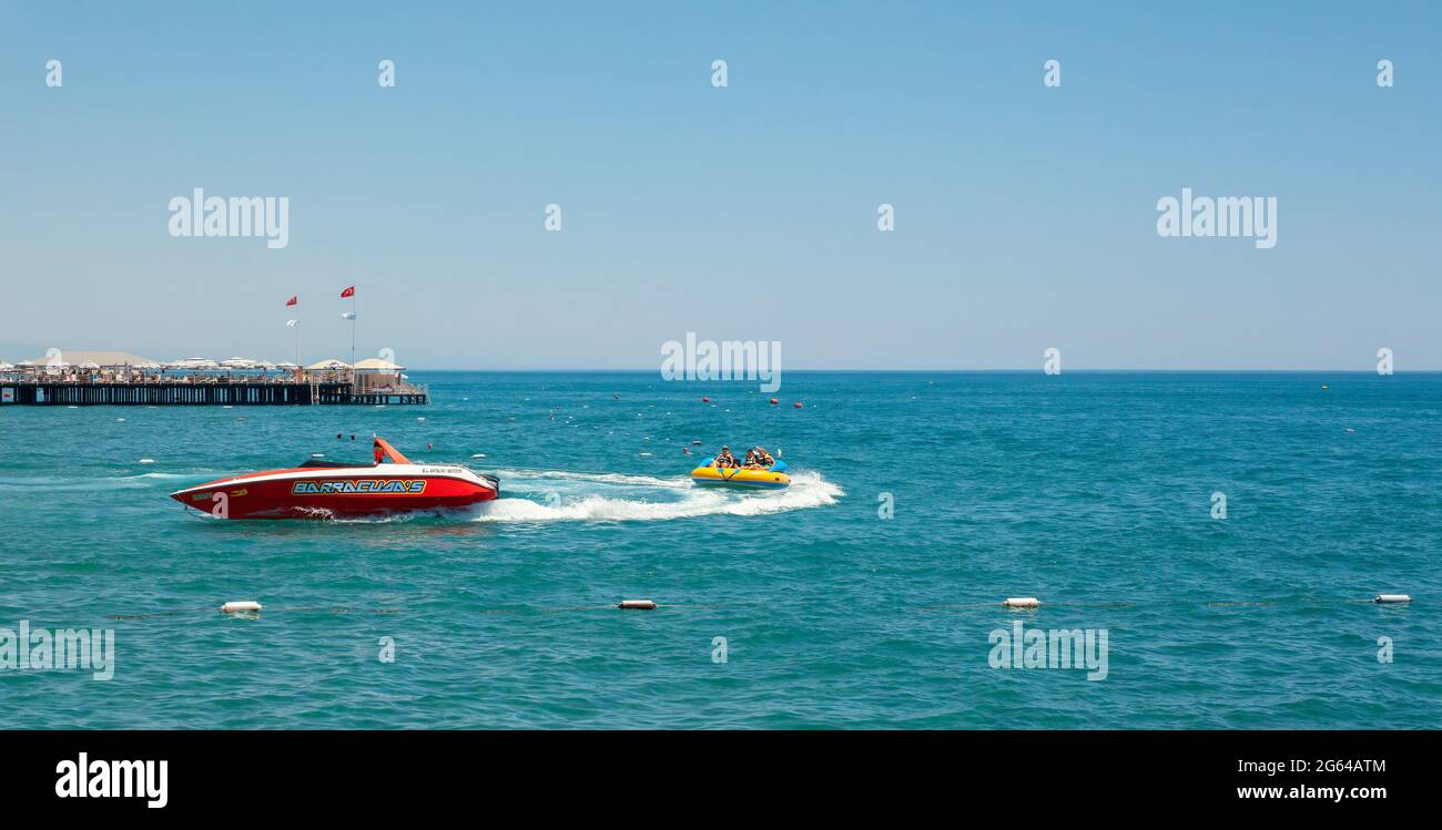 Antalya, Türkei-30. Juni 2021: Kinder haben Spaß auf aufblasbarem verrückten Sofa im Meer in den Sommerferien. Extremsport im Urlaub während einer Pandemie. Stockfoto