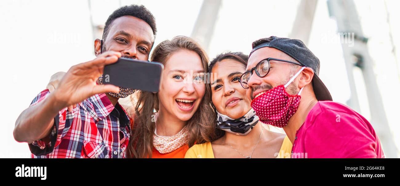 Multirassische Freunde nehmen Selfie mit Gesichtsmaske in Coronavirus Zeit - Junge Menschen Spaß im Urlaub - neues Lifestyle-Konzept Stockfoto