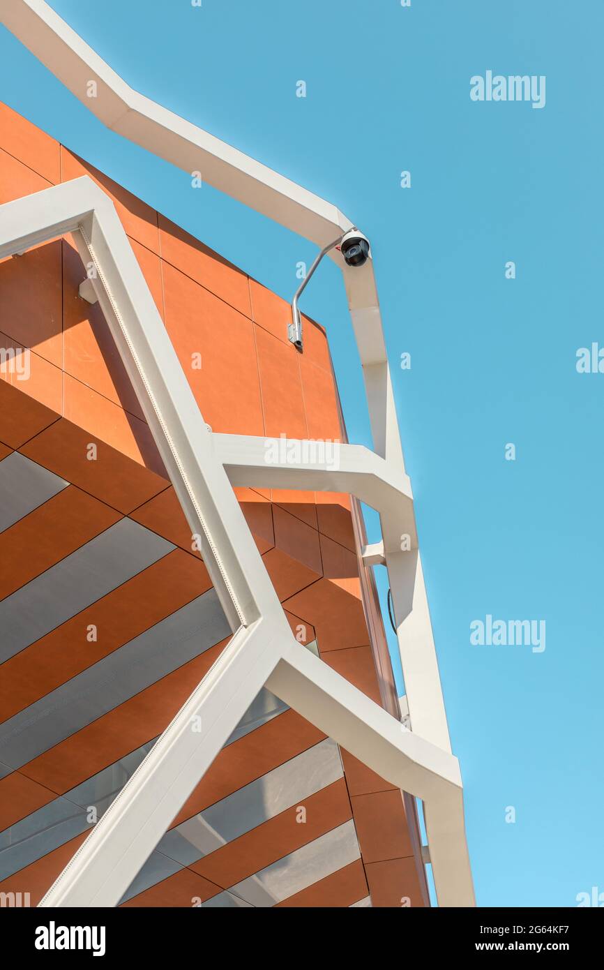 Vertikale CCTV-Außenkamera auf dem Dach des Gebäudes gegen den blauen Himmel. Stockfoto