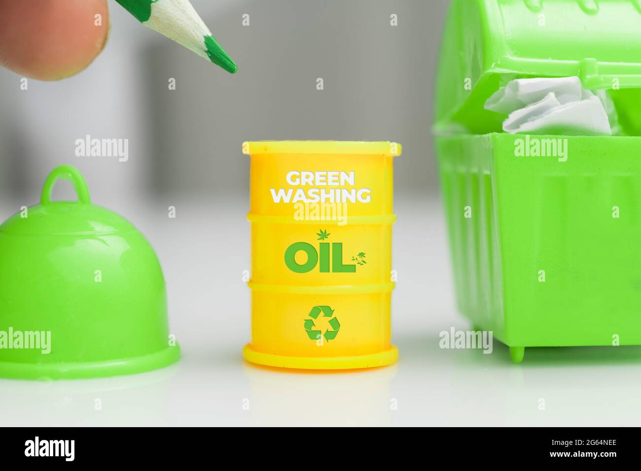 Greenwashing-Konzept. Ölfass mit Recycling-Symbol und grünem Text. Greenwashing ist eine Kommunikationstechnik, die darauf abzielt, ein falsches Bild eines CO zu erstellen Stockfoto