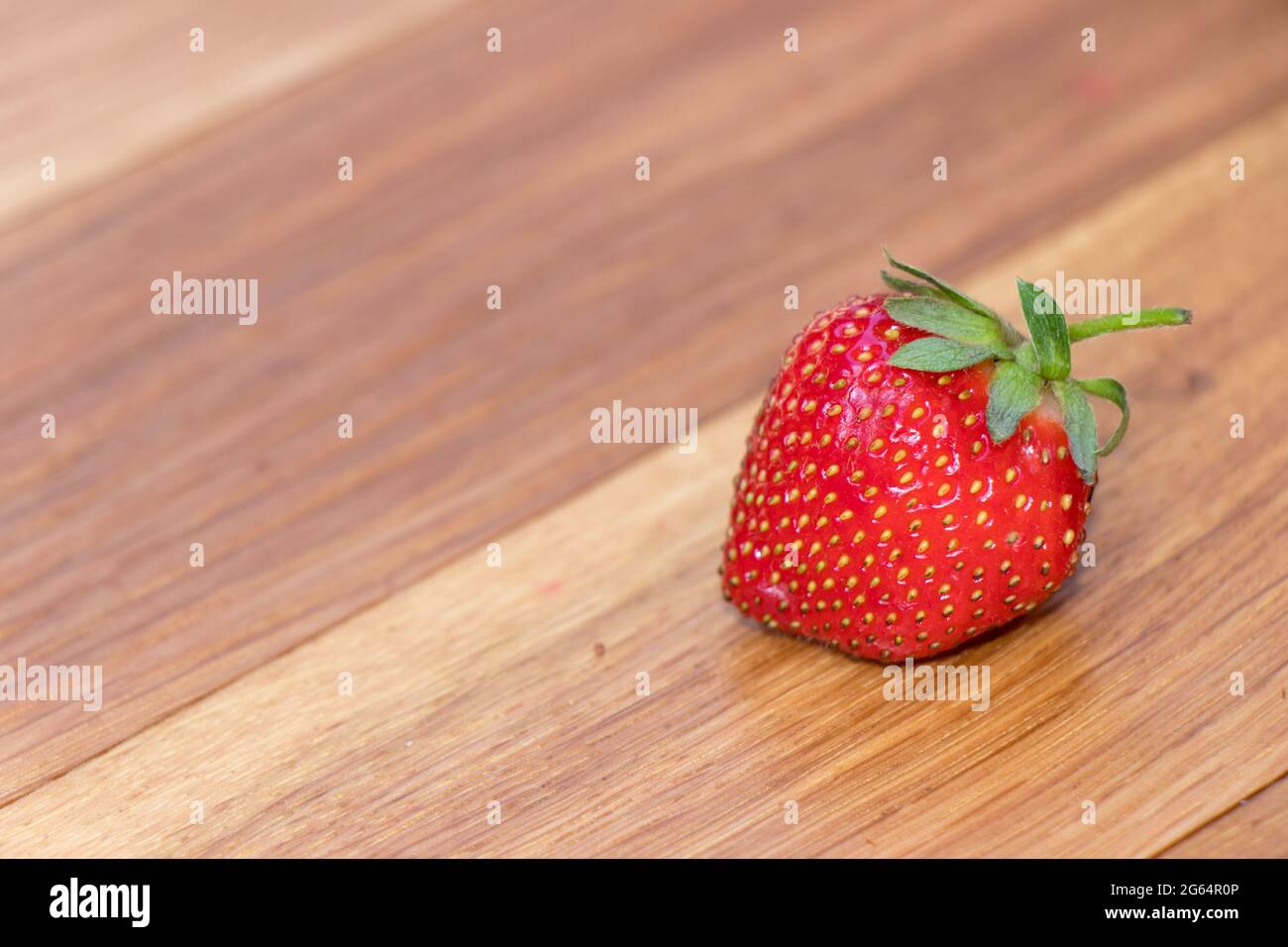 Frische Erdbeere auf Holzhintergrund. Frisch, rot und lecker Stockfoto