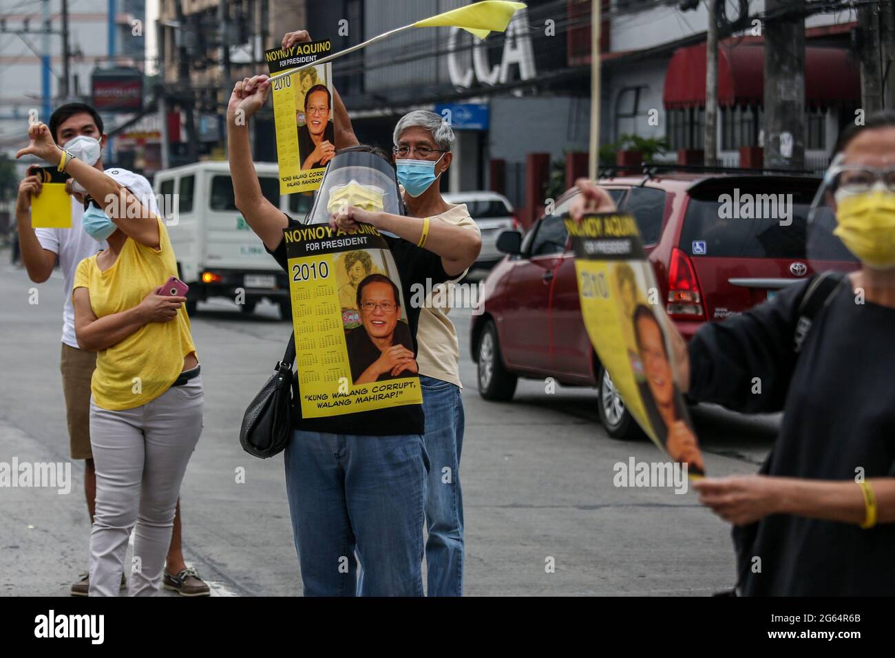 Vor seiner Beerdigung in Quezon City, Philippinen, versammeln sich Unterstützer neben der Autokolonne des ehemaligen philippinischen Präsidenten Benigno Aquino III. Stockfoto