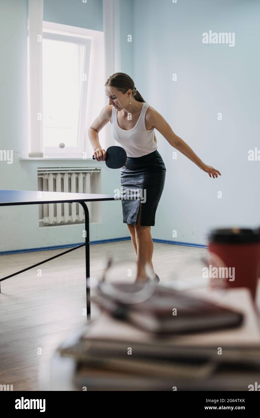 Mittagspause Freizeit, Aktivitäten zur Stressbewältigung, engagierte Büroaktivitäten. Lustige Office-Spiele. Ping-Pong-Turnier. Junge Geschäftsfrau spielt pi Stockfoto