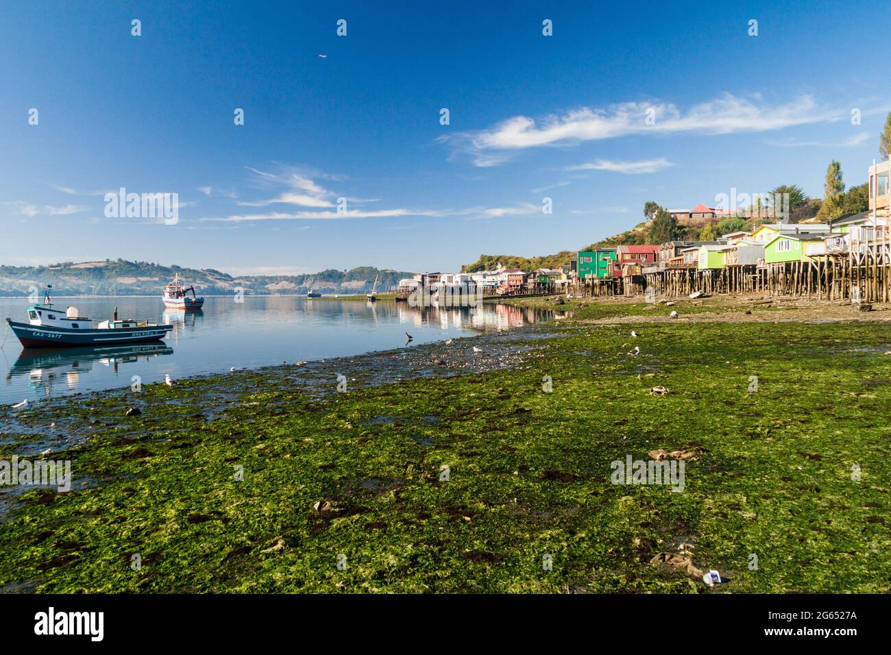 CASTRO, CHILE - 23. MÄRZ 2015: Fischerboote und Palafitos (Stelzenhäuser) bei Ebbe in Castro, Chiloe Island, Chile Stockfoto