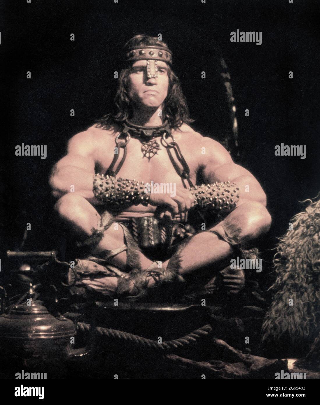 Arnold Schwarzenegger, sitzendes Porträt in voller Länge, Dreharbeiten zum Film, „Conan the Destroyer“, Universal Picters, 1984 Stockfoto