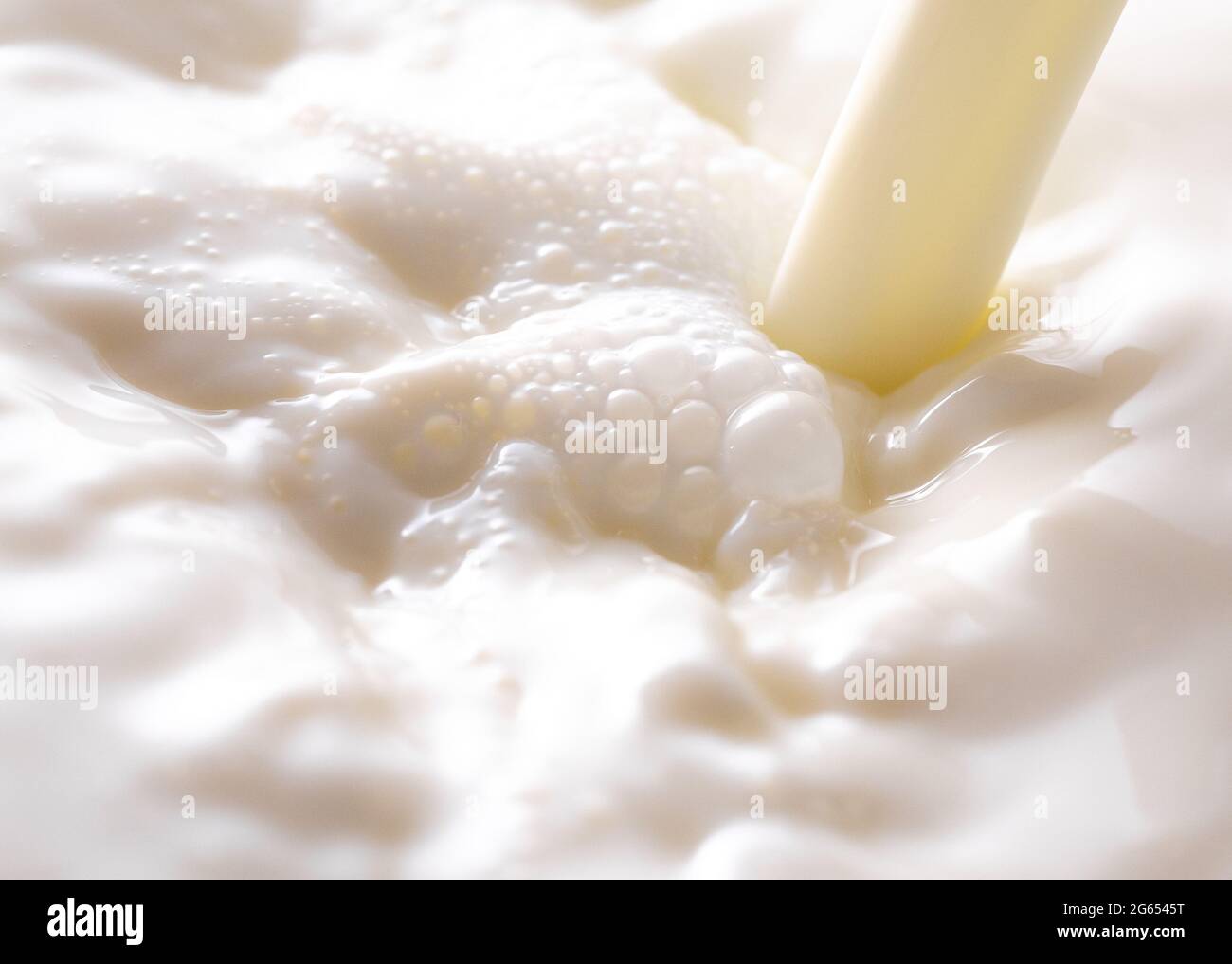 Ein Milchdampf, der in eine Schüssel Milch gegossen wird Stockfoto