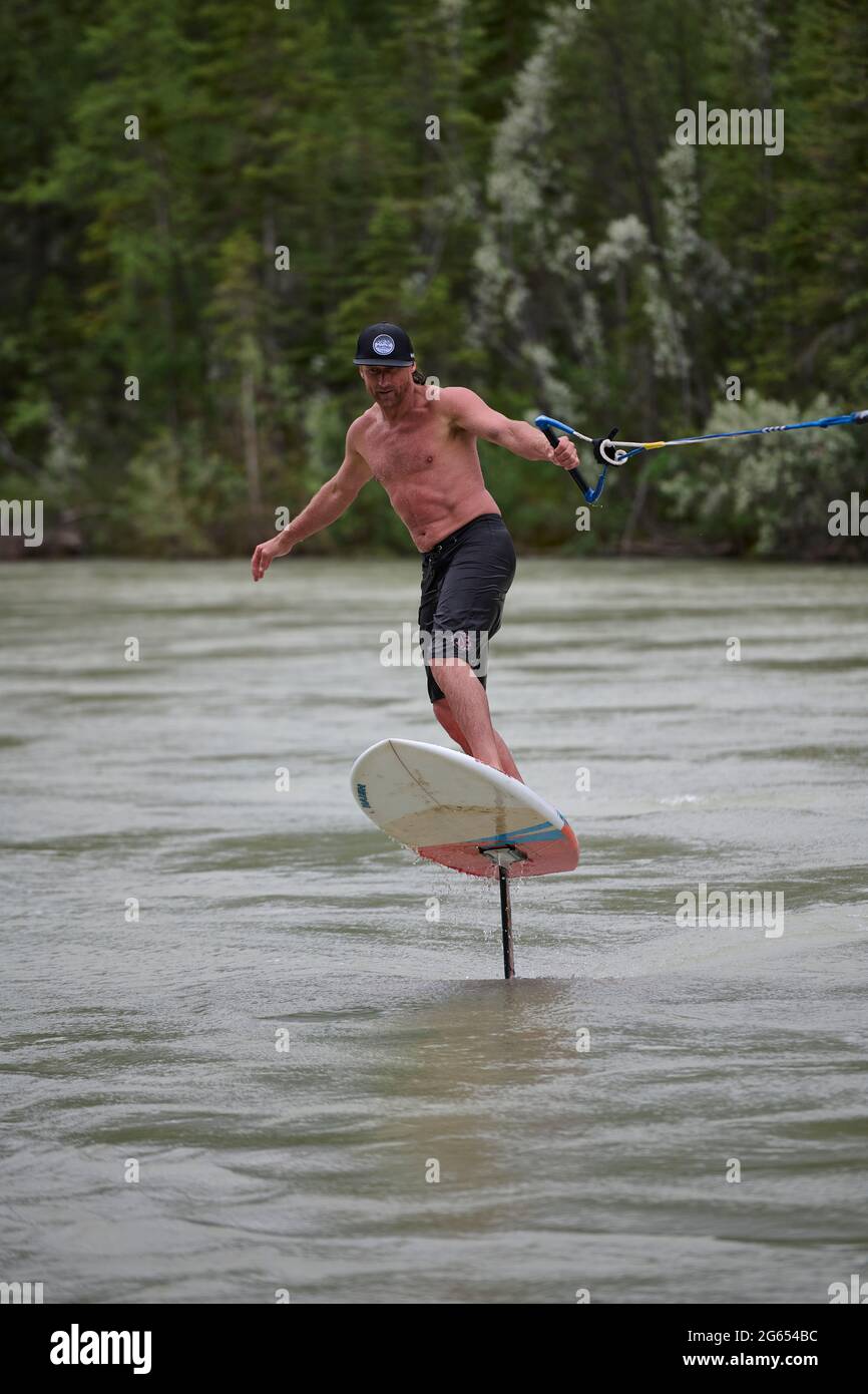 Todd Ril-Surfen (Foil Boarding) während des Flußes im Frühling im Bow River, Canmore, Alberta, Kanada. Stockfoto