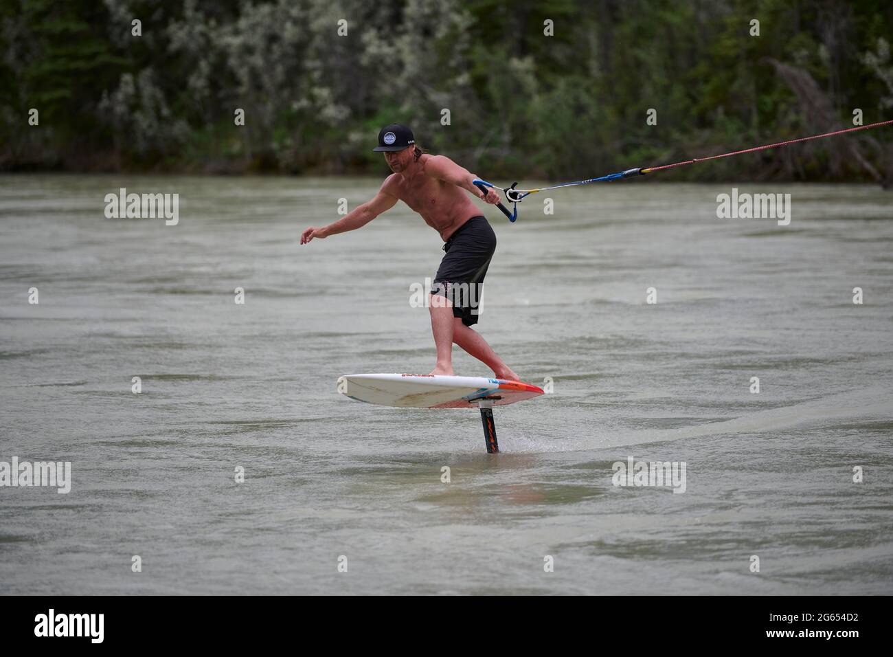 Todd Ril-Surfen (Foil Boarding) während des Flußes im Frühling im Bow River, Canmore, Alberta, Kanada. Stockfoto