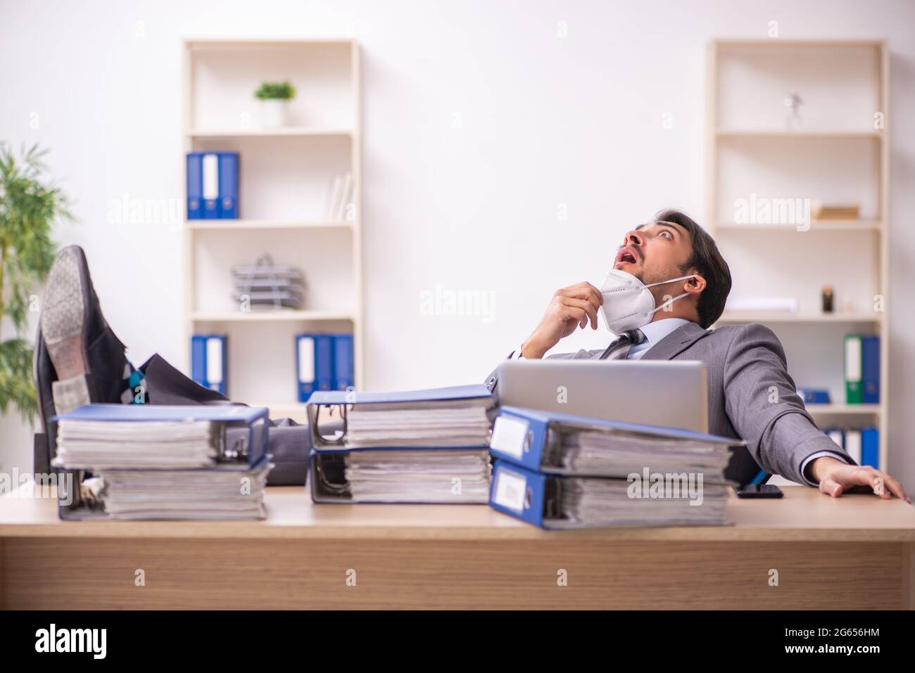 Junger Geschäftsmann, der während einer Pandemie am Arbeitsplatz arbeitet Stockfoto