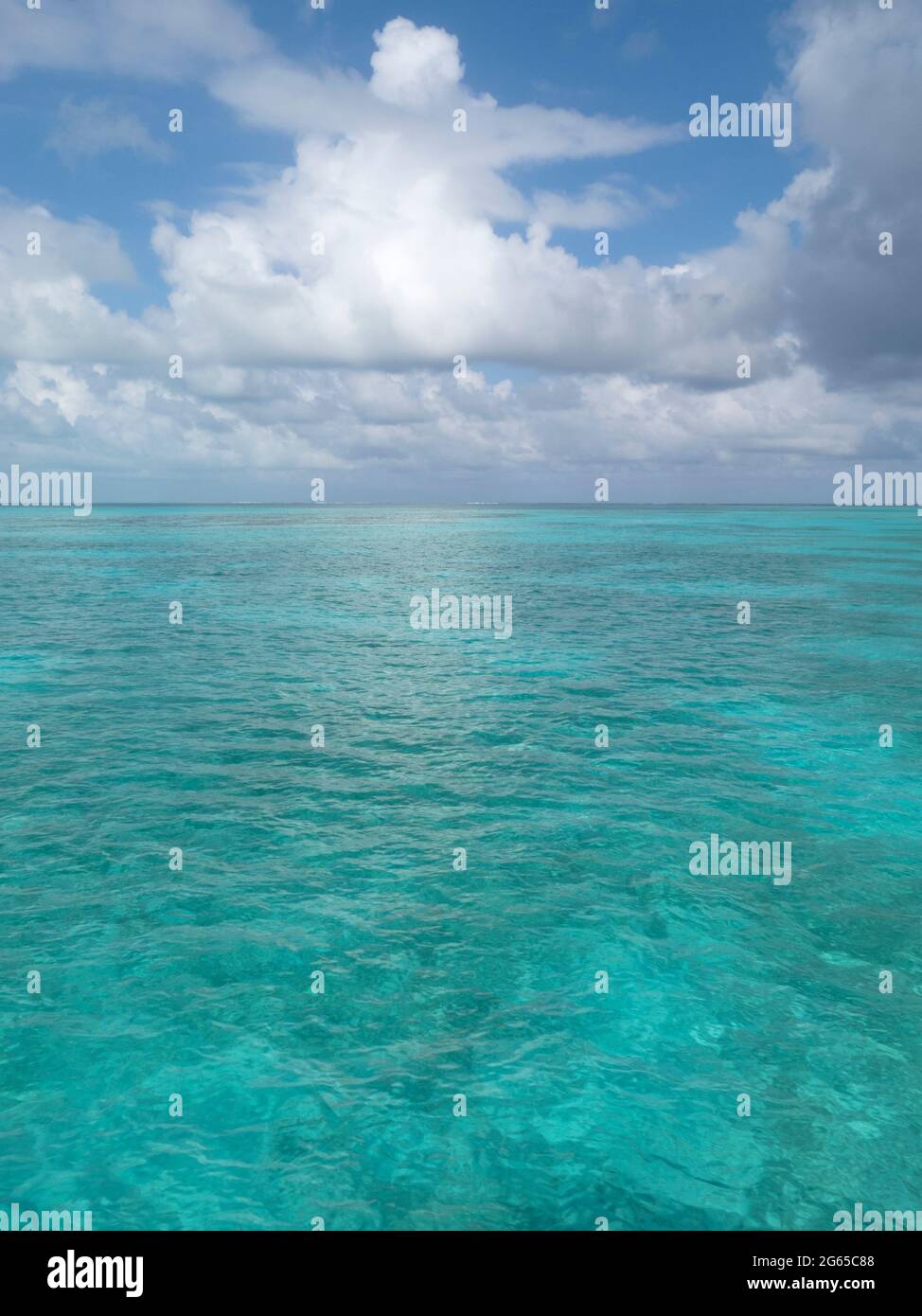 Petrol / Blau Wasser plätschert unter geschwollenen weiße Wolken. Stockfoto