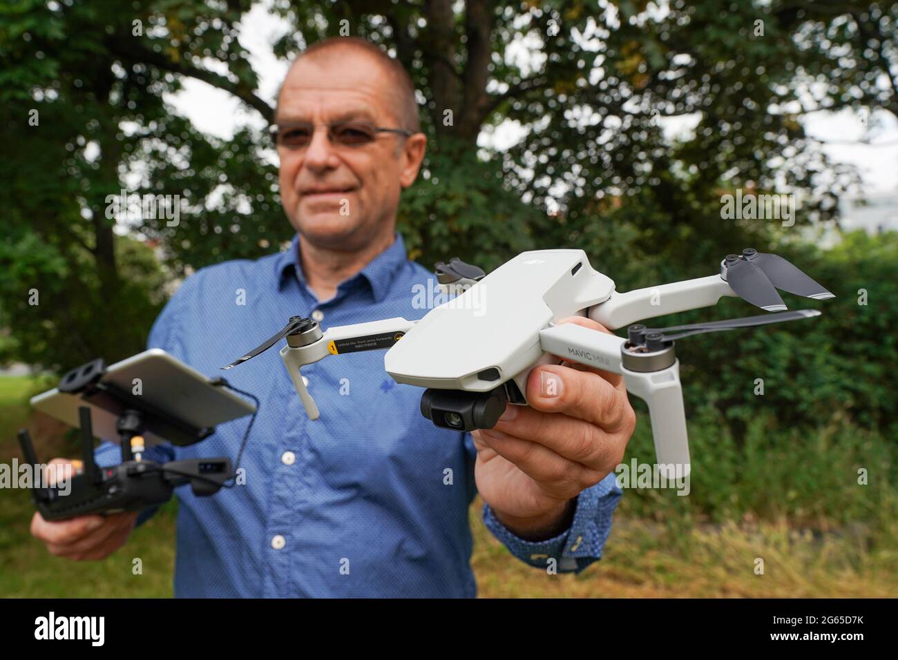 Leipzig, Deutschland. Juli 2021. Ralph Werner von der Quadrocopter Flight  School hält eine Drohne, einen DJI Mavic Mini, in einem Park. Weber bietet  Drohnenpiloten Kurse in sicherem Drohnenflug an. Fliegende Drohnen kommen