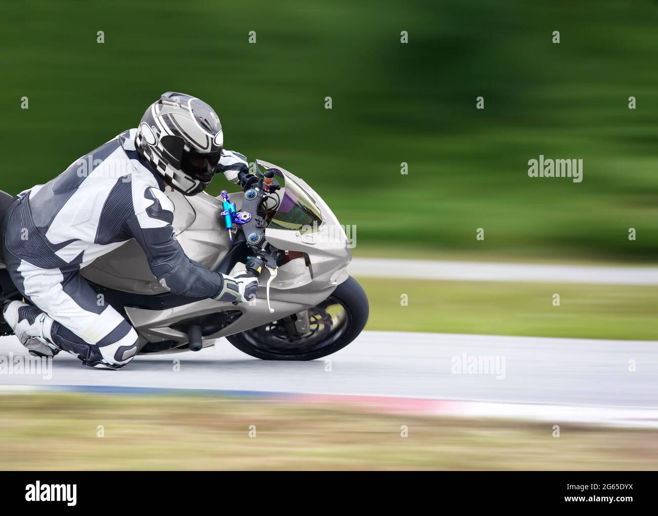 Motorrad-Praxis lehnt sich in eine schnelle Ecke auf der Strecke Stockfoto