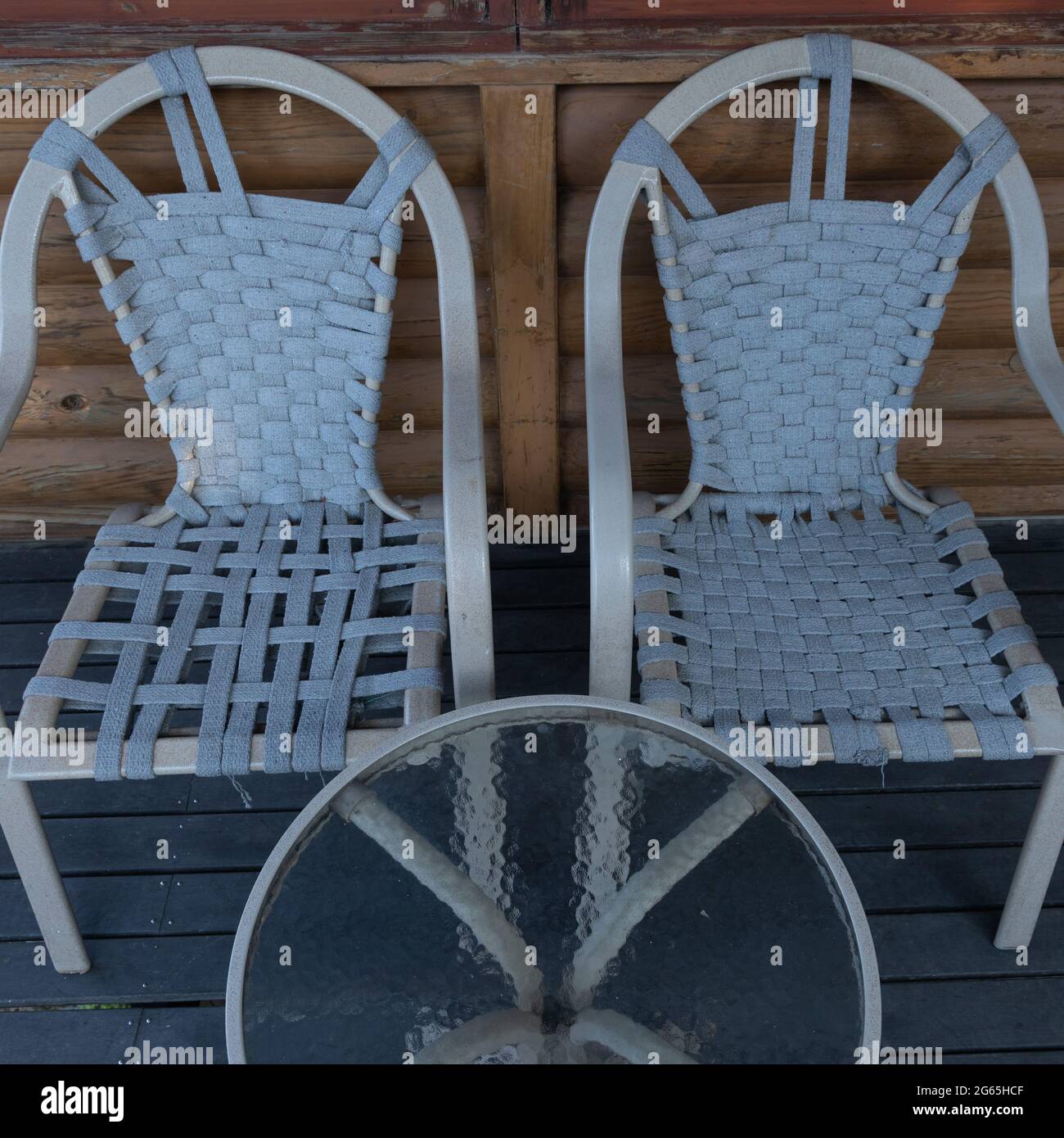 Ein Paar Stühle und ein runder Tisch mit Glas nebeneinander Stockfoto