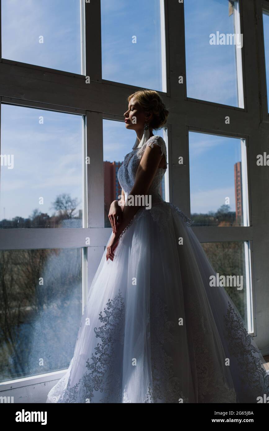 Kunstfoto einer sanften hübschen Frau mit blondem, Braut, wunderschönen teuren weißen Kleid Stockfoto