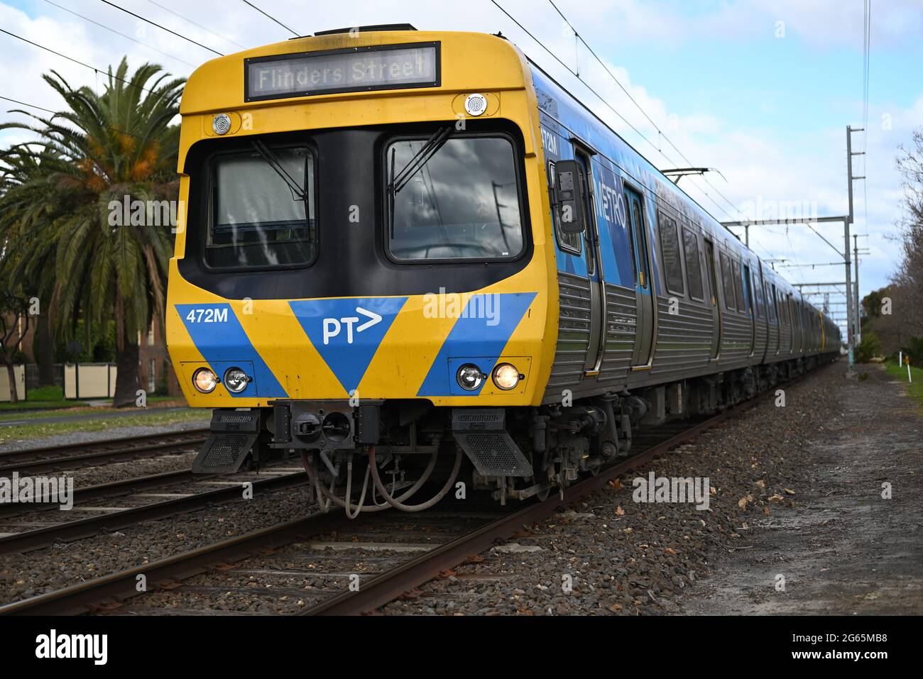 Ein Service der Flinders Street, der von den Metrozügen Melbourne kurz nach der Abfahrt von der Station Ormond angeboten wird. Auf dem Comeng-Zug ist Schmutz deutlich zu sehen. Stockfoto