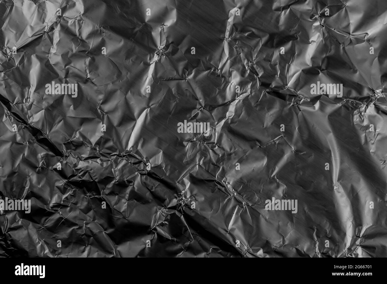 Schwarz zerkleinert beschädigte Aluminium-Metallfolie Textur. Grungen Sie Falten. Abstrakter dunkler Hintergrund Stockfoto