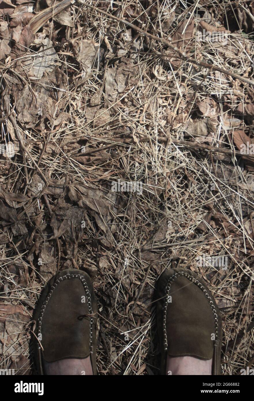 Zwei Füße stehen auf ausgetrocknetem Garten. Stockfoto