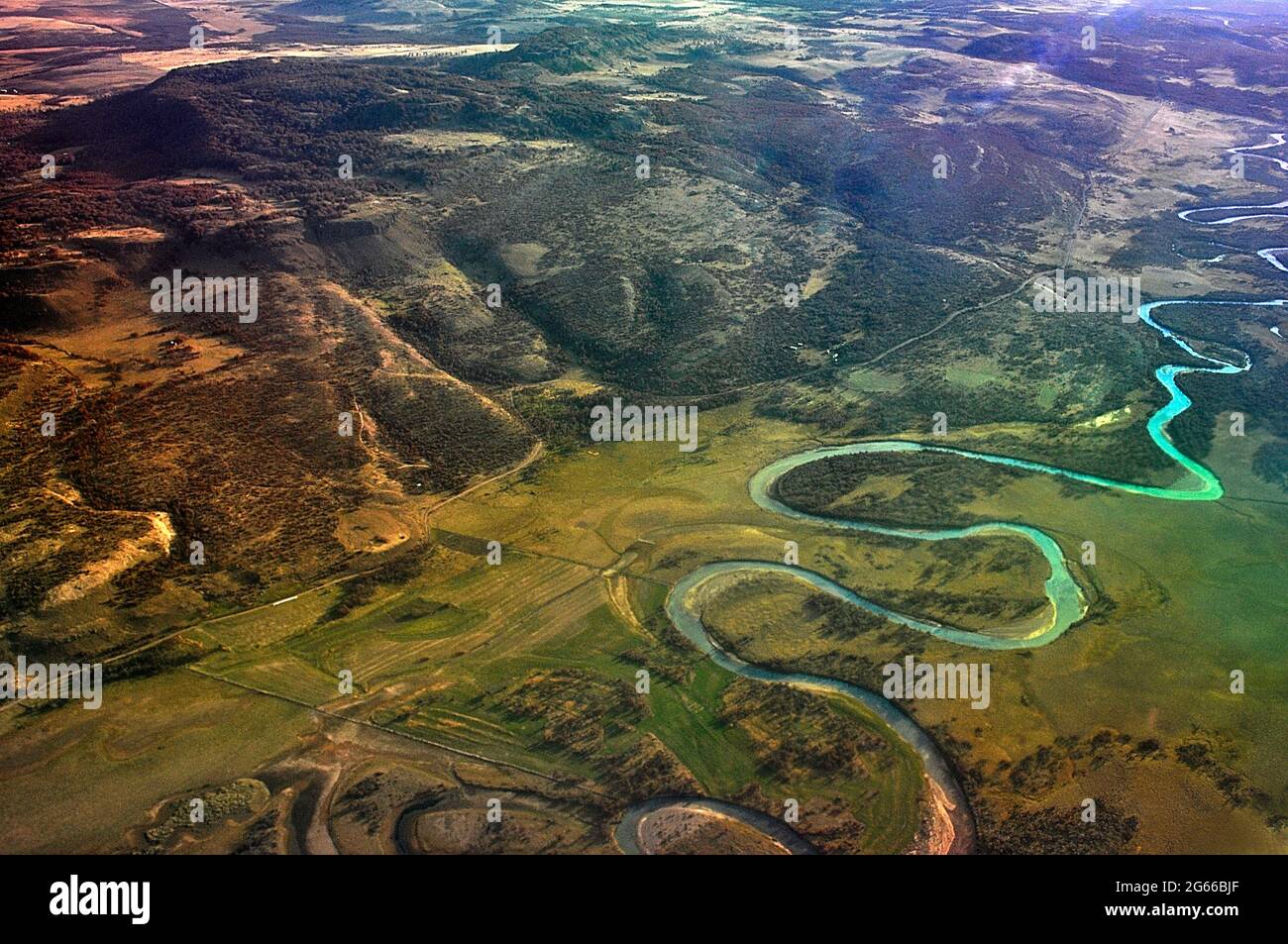 Fliegen über Patagonien, Chile auf 30000 Fuß an einem sonnigen Tag. Luftaufnahme zeigt die physische Landschaft - Hügel, ein gewundener Fluss und anderes Gelände. Stockfoto