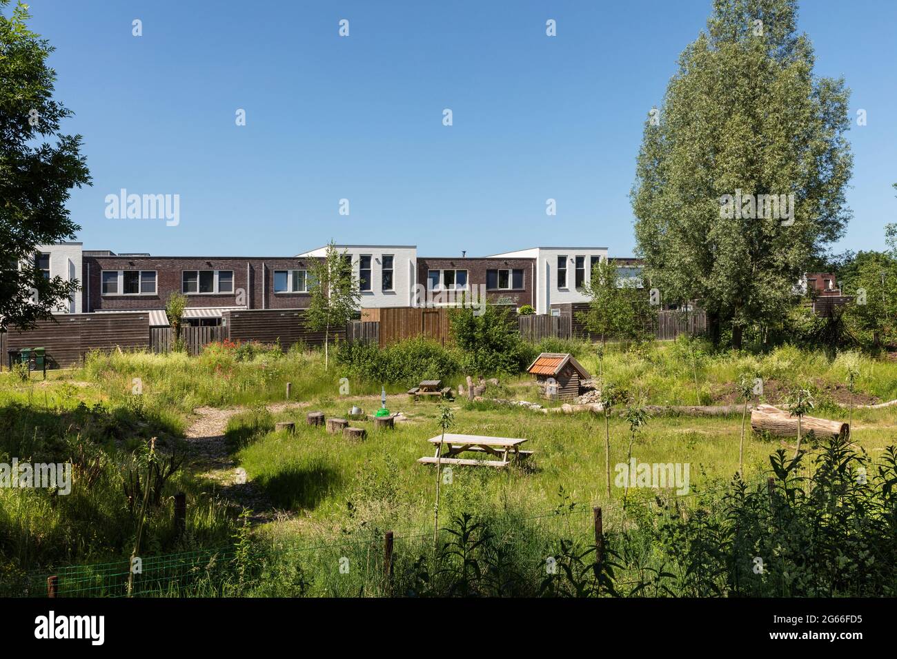 Eersel, Niederlande 13. Juni 2021. Neu gebaute Häuser mit einem Gemeinschaftsgarten mit Bänken, einem Insektenhotel und viel Grün für Leute zum Treffen, Genießen Stockfoto