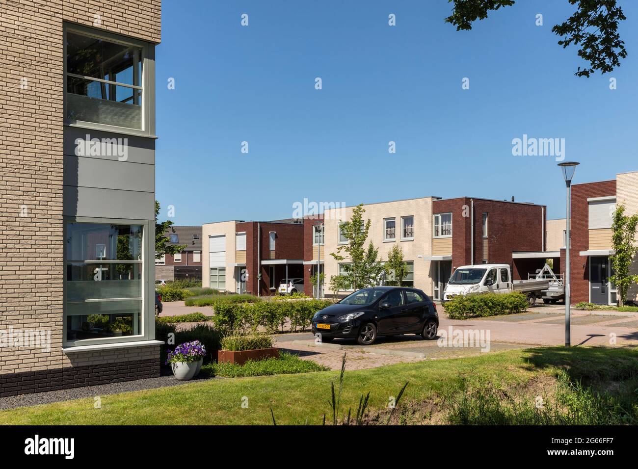 Eersel, Niederlande 13. Juni 2021. Neu gebaute Häuser mit Garten, Grün, geparkten Autos an einem sonnigen Tag im Sommer und einem blauen Himmel Stockfoto