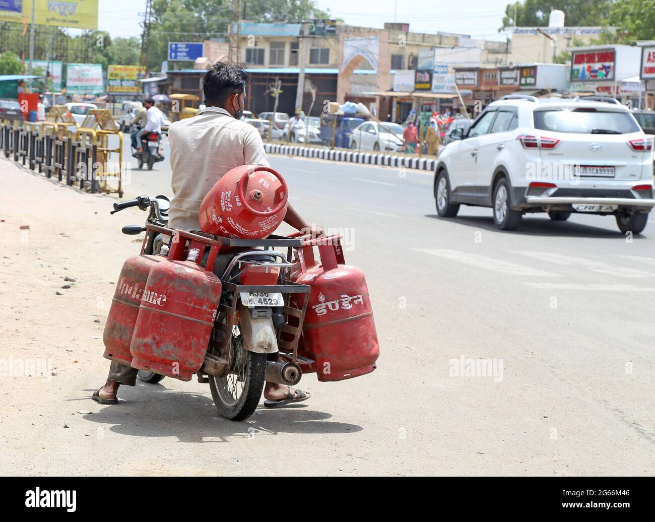Beawar, Rajasthan, Indien, 3. Juli 2021: Ein Arbeiter trägt Treibgasflaschen auf einem Fahrrad in Beawar. Der Preis für nicht subventionierte Treibgasflaschen, die um 25.50 Rs und kommerzielle Treibgasflaschen um 84 Rs angefahren wurden, ist wirksam. Kredit: Sumit-Samarwat/Alamy Live Nachrichten Stockfoto