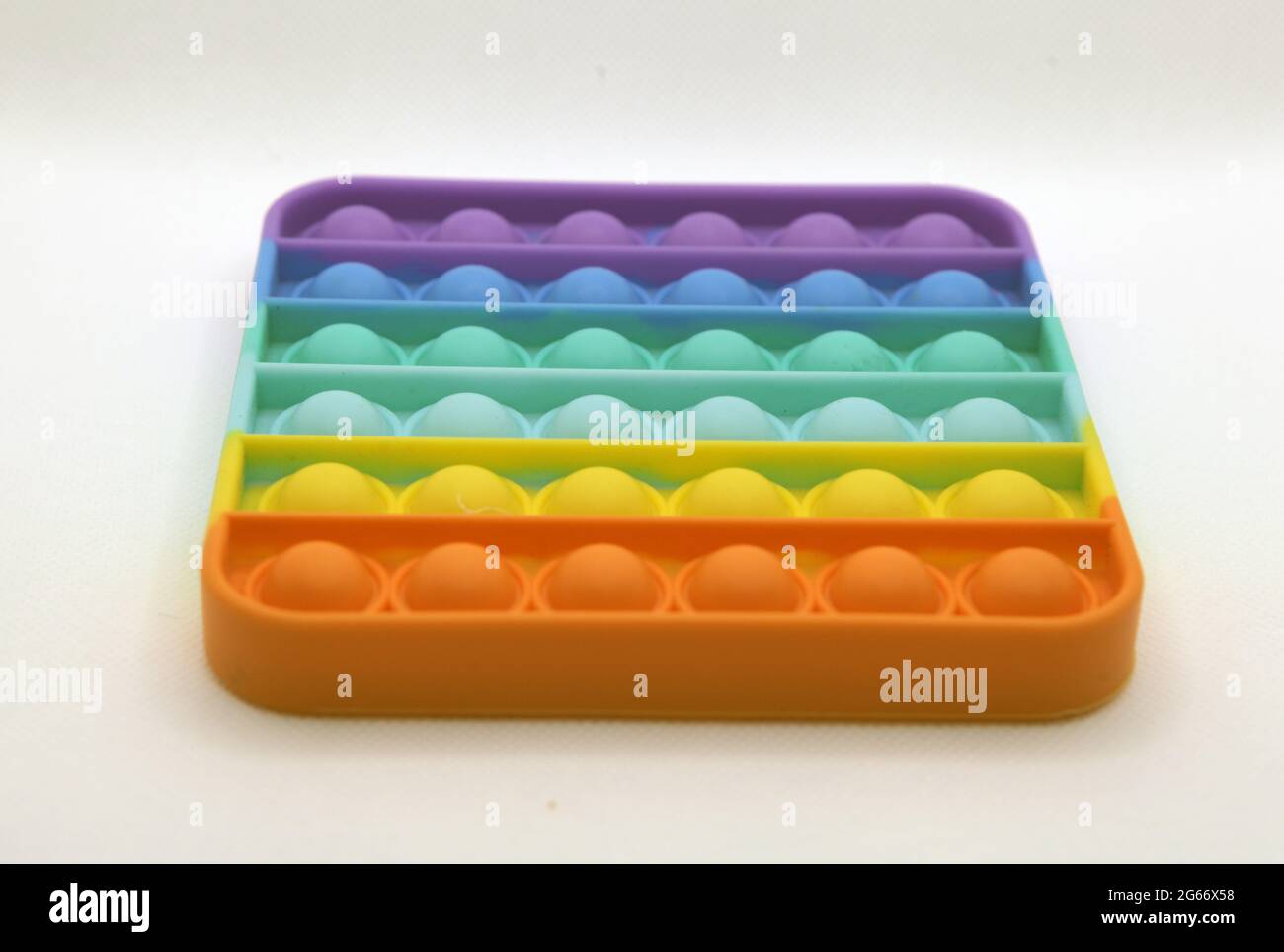 Rainbow farbige Pop it Spielzeug auf einem weißen Hintergrund Stockfoto