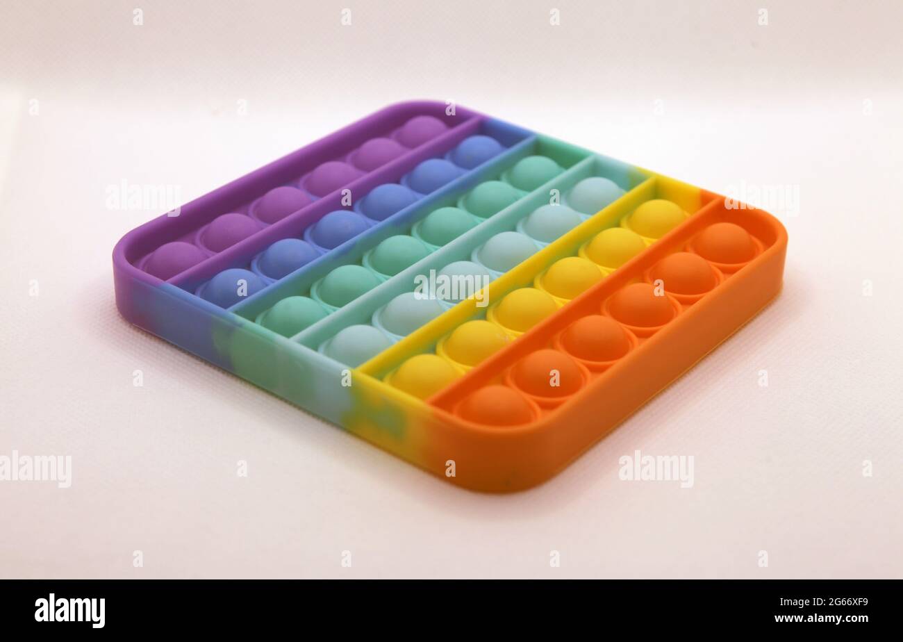 Rainbow farbige Pop it Spielzeug auf einem weißen Hintergrund Stockfoto