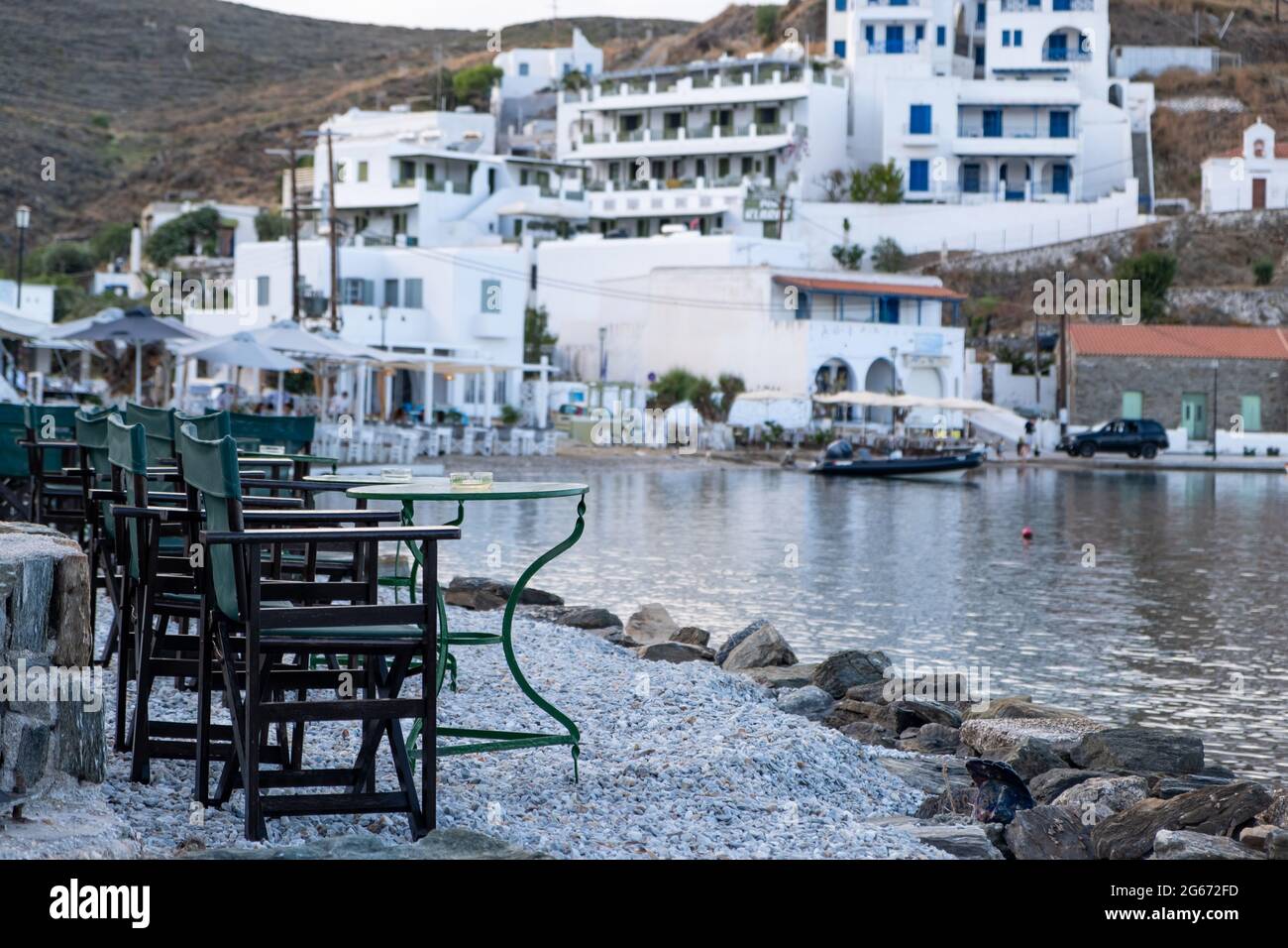 Griechische Insel, Café-Bar im Freien. Typische Cafeteria am Meer mit Tischen und Stühlen. Leere Plätze am Meer, Abend auf Kythnos. Loutra Port, Griechenland. So Stockfoto