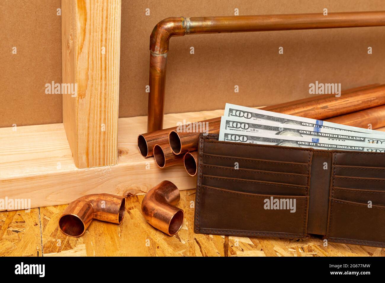 Kupferrohr und Geld in der Brieftasche. Kostenkonzept für Bau, Reparatur und Hauswartung Stockfoto