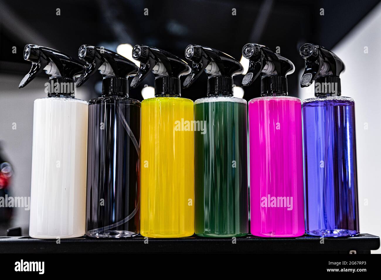Bunte Sprühflaschen mit verschiedenen chemischen Flüssigkeiten Stockfoto