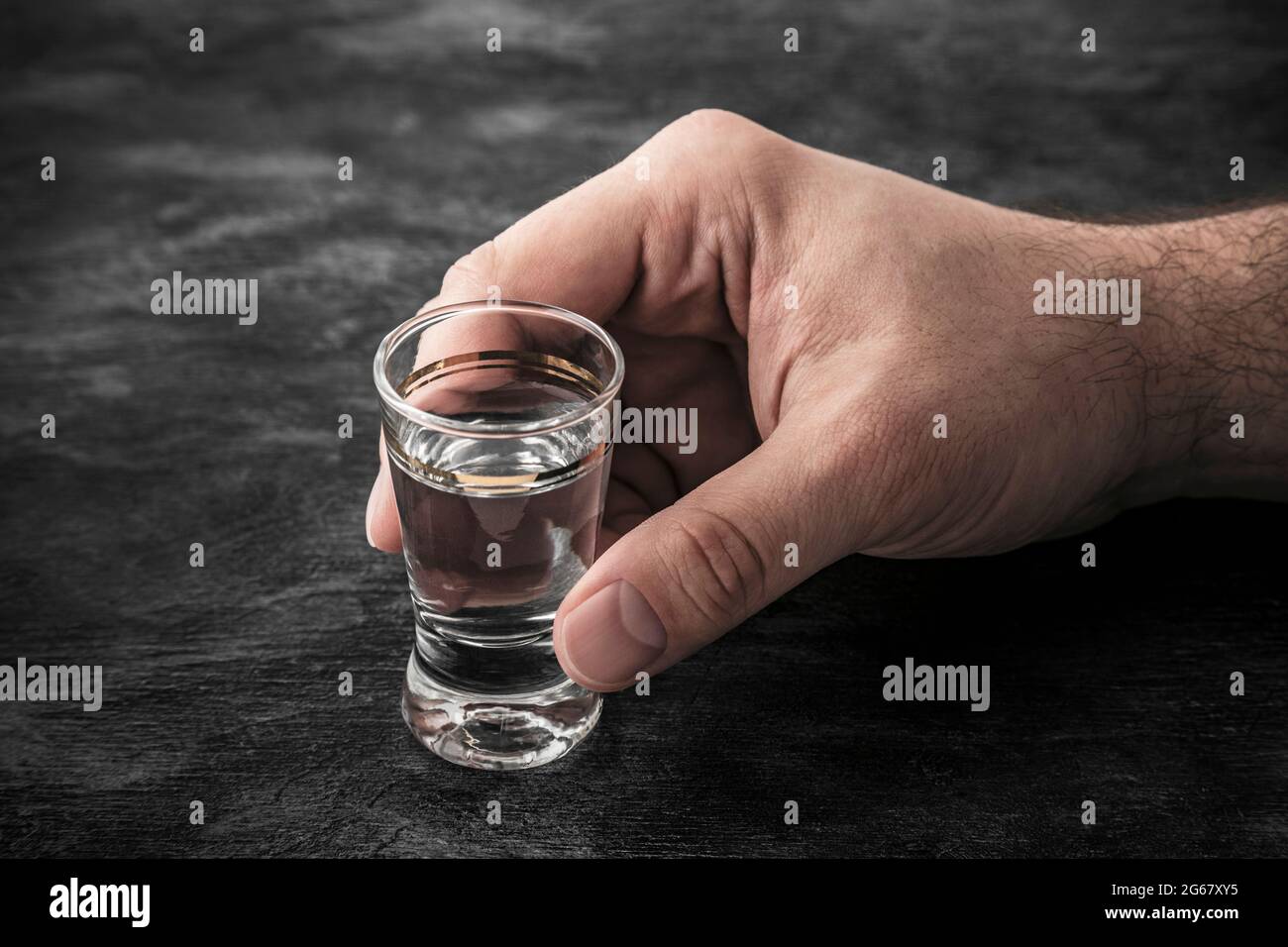 Hand mit einem Glas Wodka. Alkoholismus-Konzept. Stockfoto