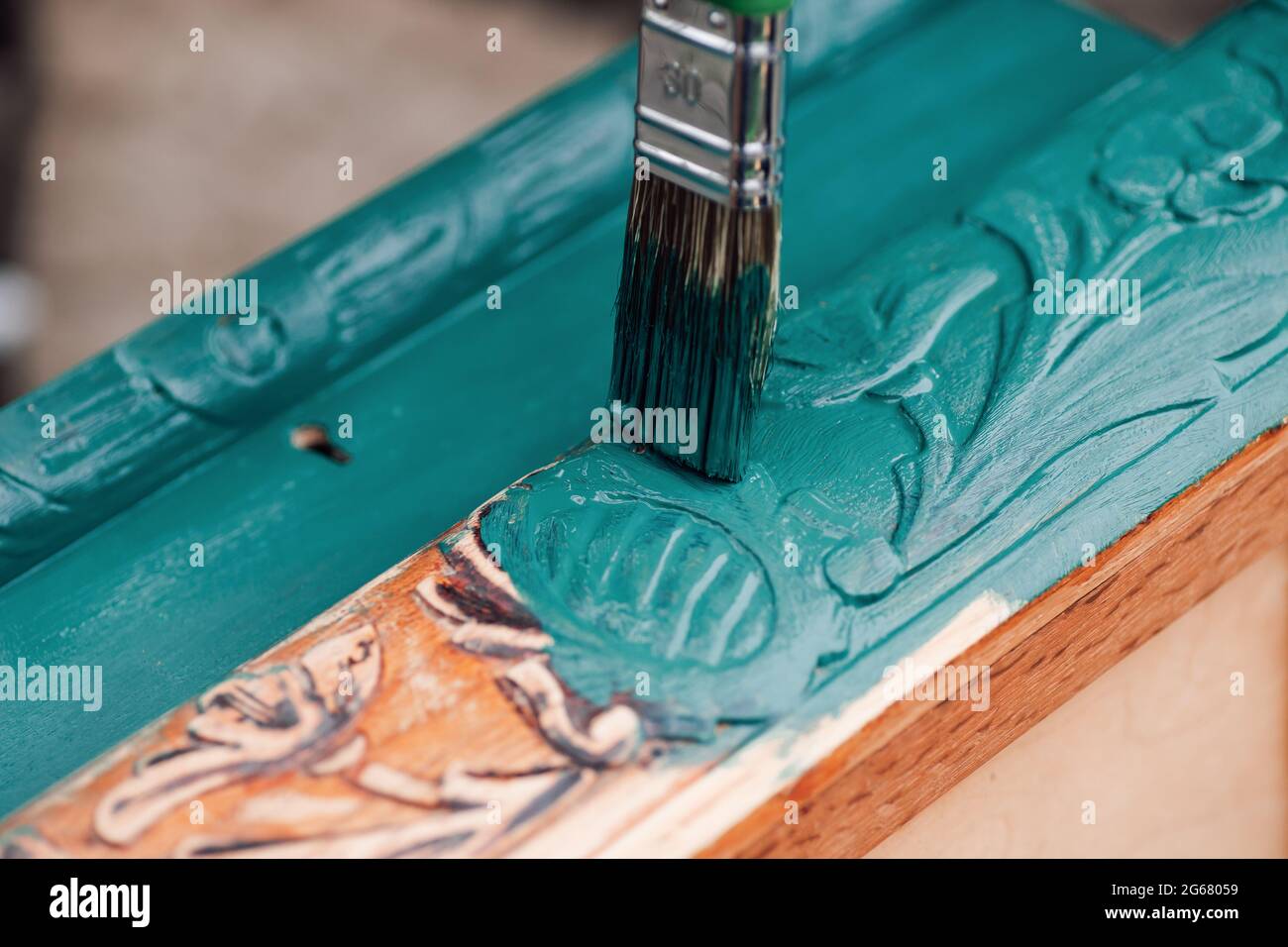 Pinsel mit blauer oder grüner Farbe Makro malen alte Holzmöbel für die Wiederverwendung, umweltfreundliche Lebensweise Stockfoto