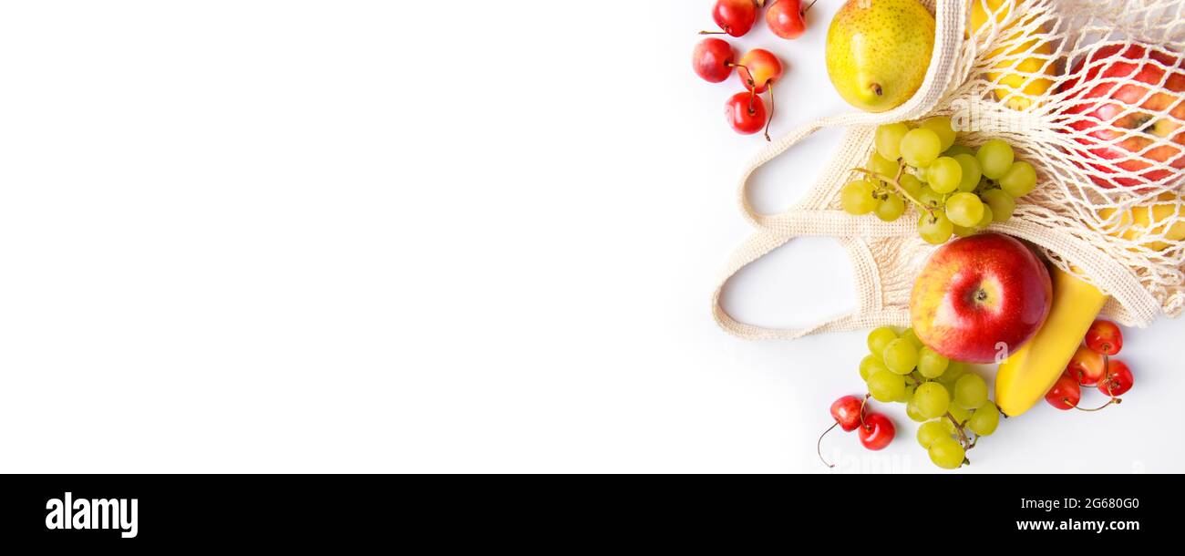 Reife Früchte in umweltfreundlichem Netzbeutel auf weißem Hintergrund. Vegane Bio-Lebensmittel. Modische Saitentasche. Gesundes Essen und nachhaltiges Lifestyle-Konzept. B Stockfoto