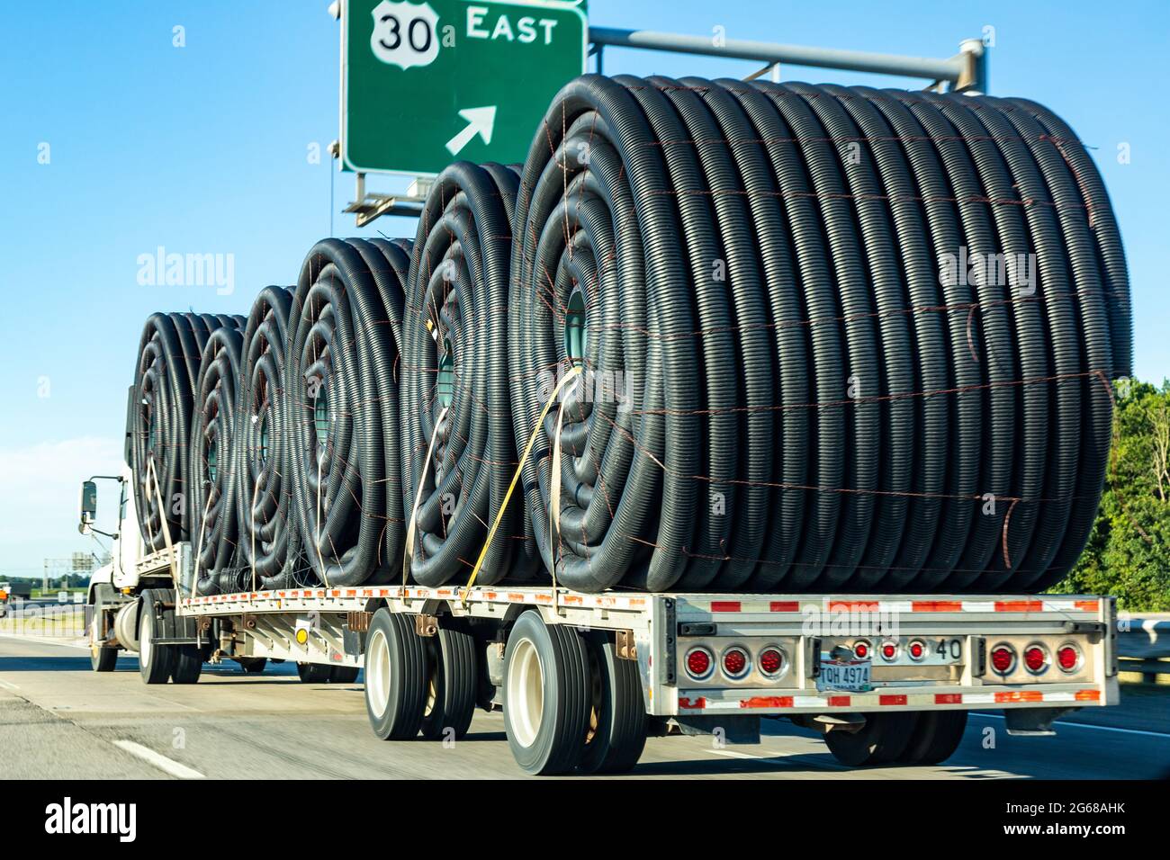 Ein Flachbett trägt eine Last von Schläuchen auf der I-469 bei US 30 durch New Haven, Indiana, USA. Stockfoto