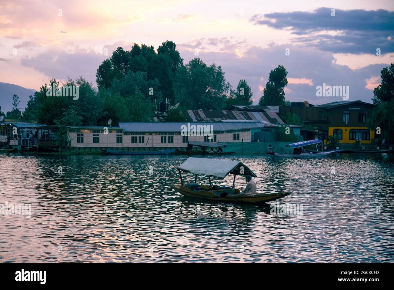 Srinagar, Indien. Juli 2021. Am Abend rudert ein Mann sein Shikara-Boot auf dem Dal Lake. Wettermänner prognostizierten für die nächsten fünf Tage hauptsächlich „heißes und trockenes“ Wetter in Jammu und Kaschmir. (Foto von Idrees Abbas/SOPA Images/Sipa USA) Quelle: SIPA USA/Alamy Live News Stockfoto